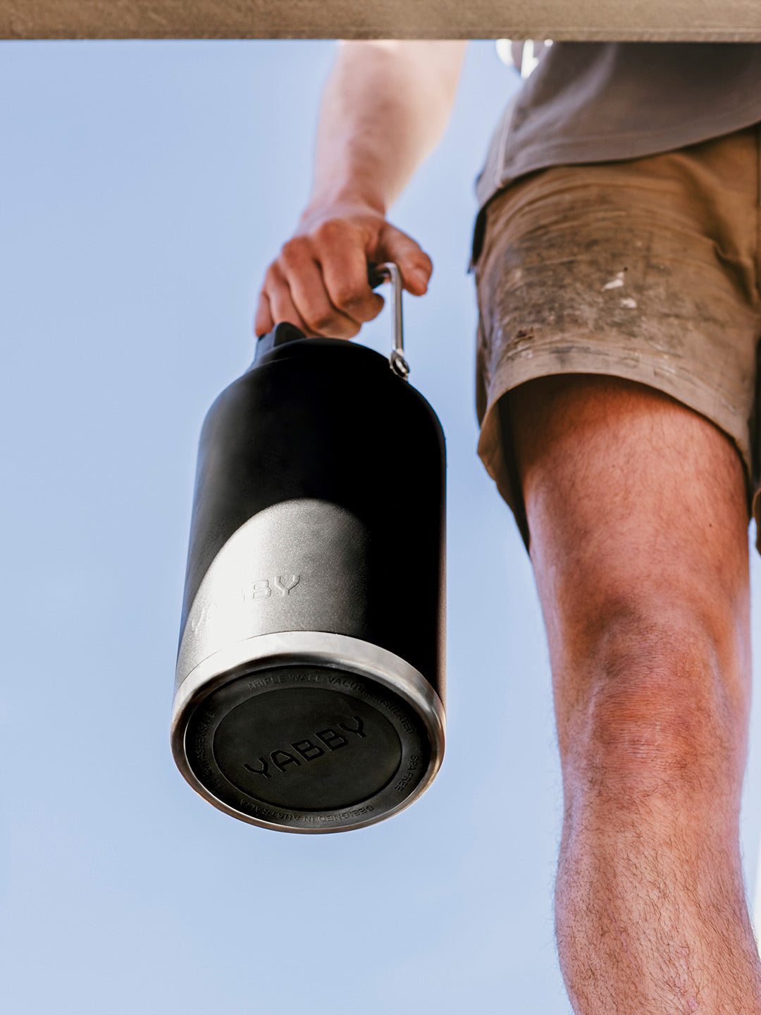 3.8 Litre Yabby Black Jug Insulated Stainless Steel. Man carrying by the Handle outdoors. Triple Wall. Keep Hot and Cold for longer. Best Black Jug Australia.