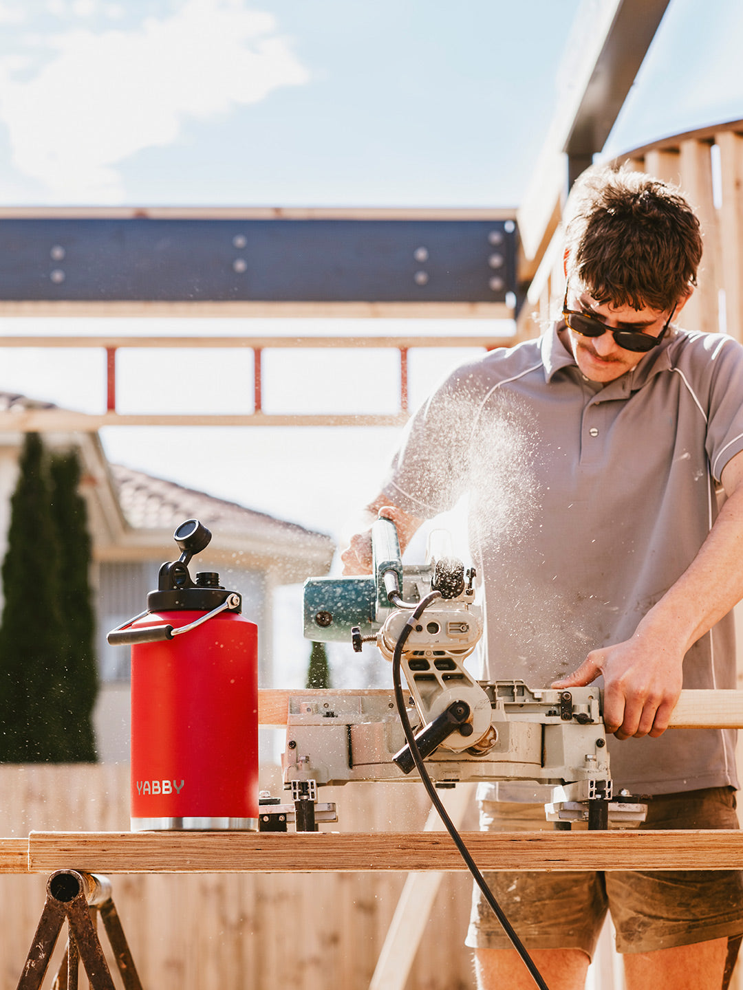 Man working outdoors with 3.8 Litre Red Jug Insulated Stainless Steel by Yabby Outdoors. Best Jug Australia.