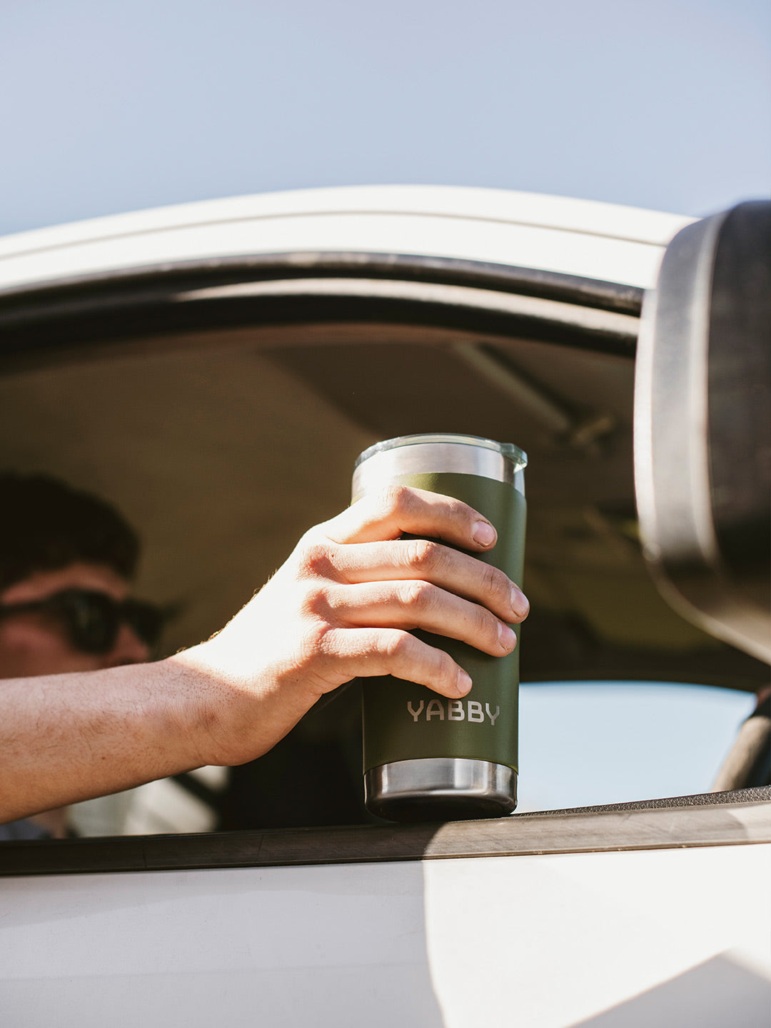 Travelling in Car with the Best Coffee Tumbler in Green. Made from Insulated Stainless Steel with Triple wall to keep drinks hot and cold for longer. 600ML size. By Yabby Outdoors.