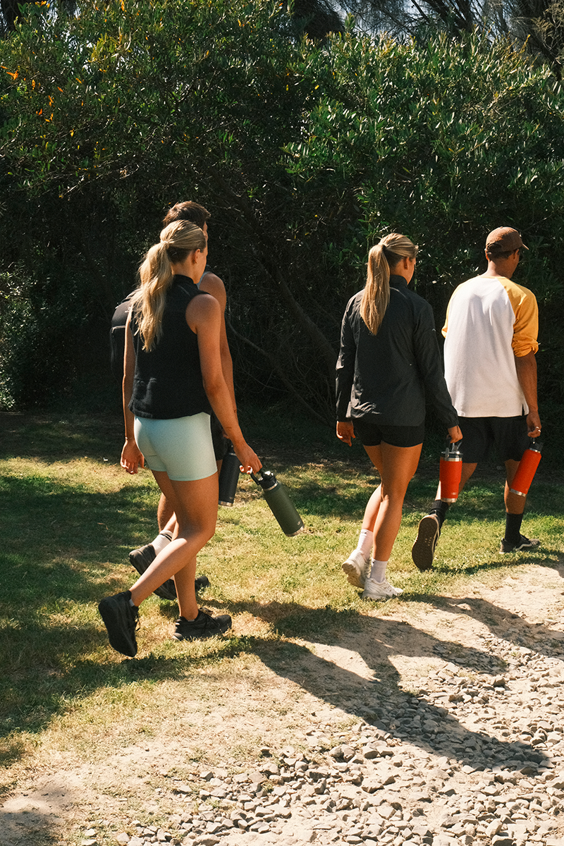 Four people walking in greenery with their Yabby insulated, stainless steel drink bottles in hand.